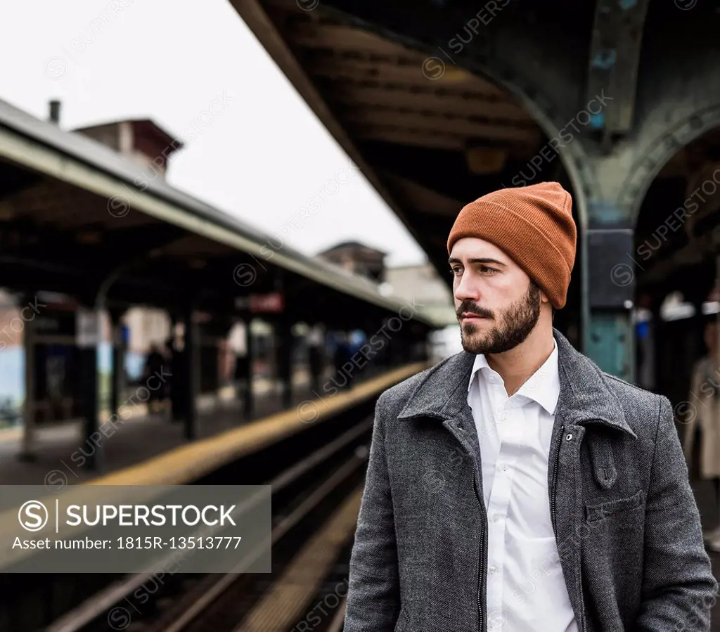 Young man waiting at metro station platform