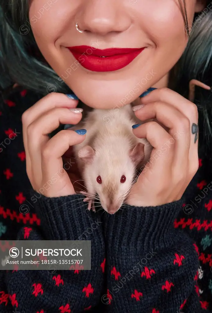 Smilig young woman with pet rat in her hands