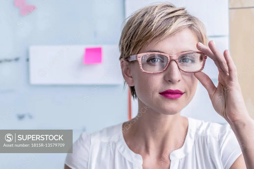 Portrait of businesswoman in front of whiteboard in modern office