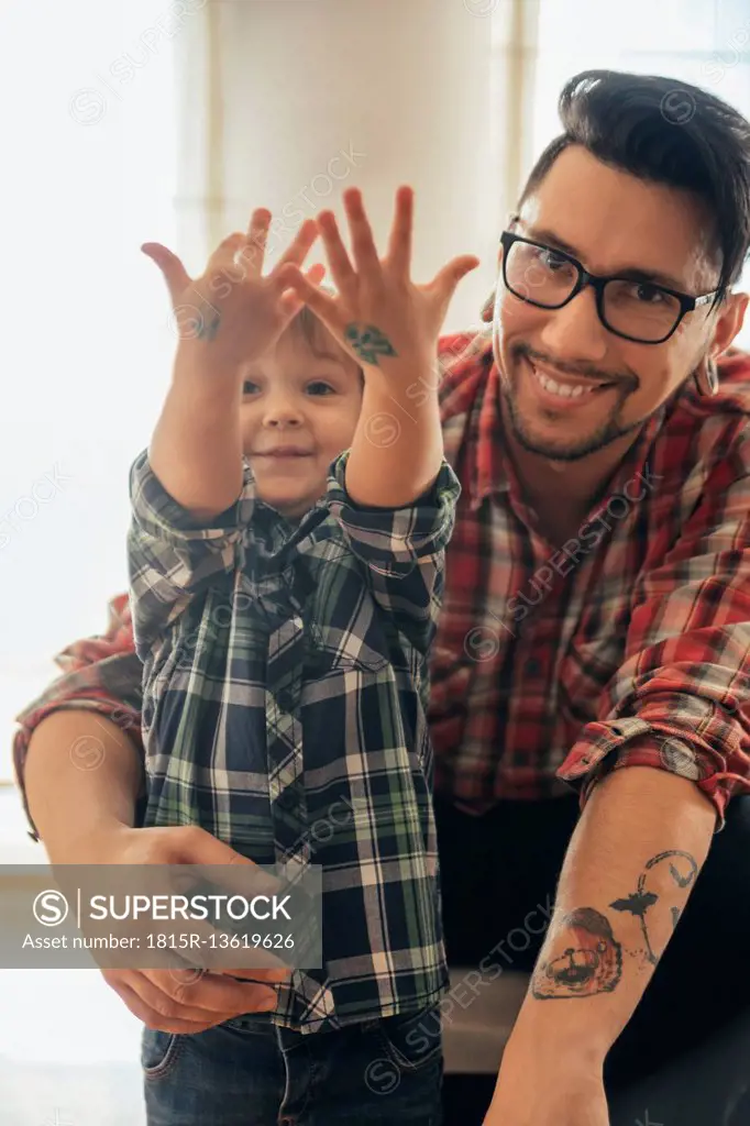 Proud son showing painted tattoos on his hands