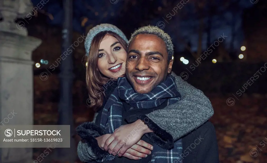 Portrait of happy young couple in front of park