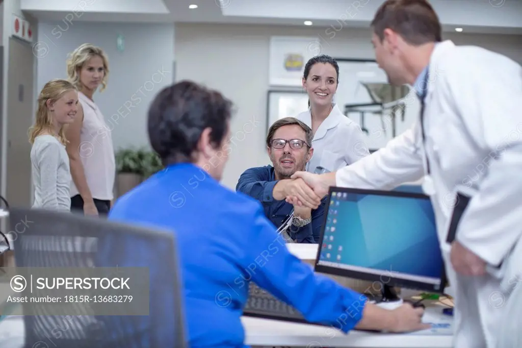 Patient in wheelchair greeting doctor at the reception