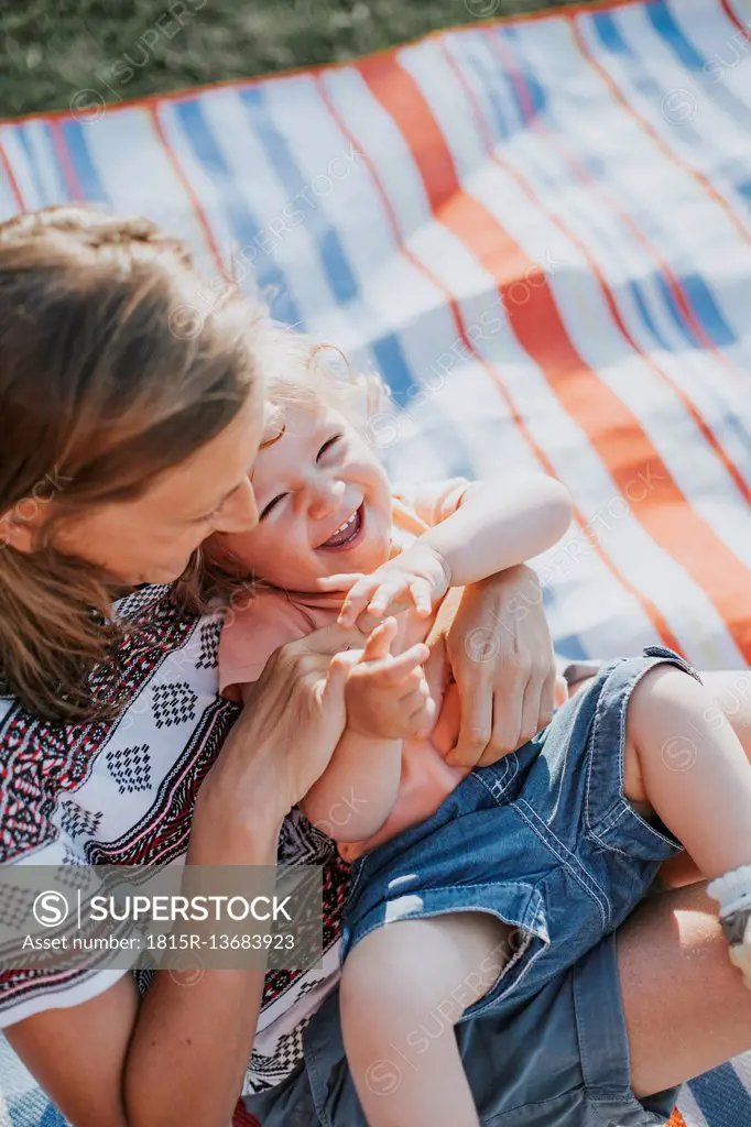 Mother tickling her little daughter