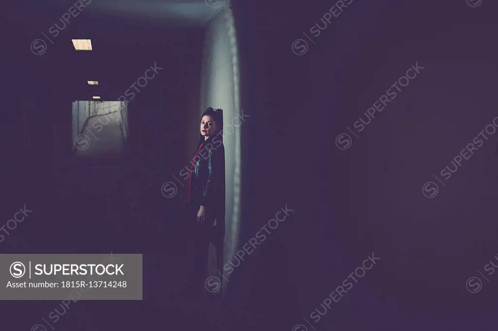 Young woman in dark underpass