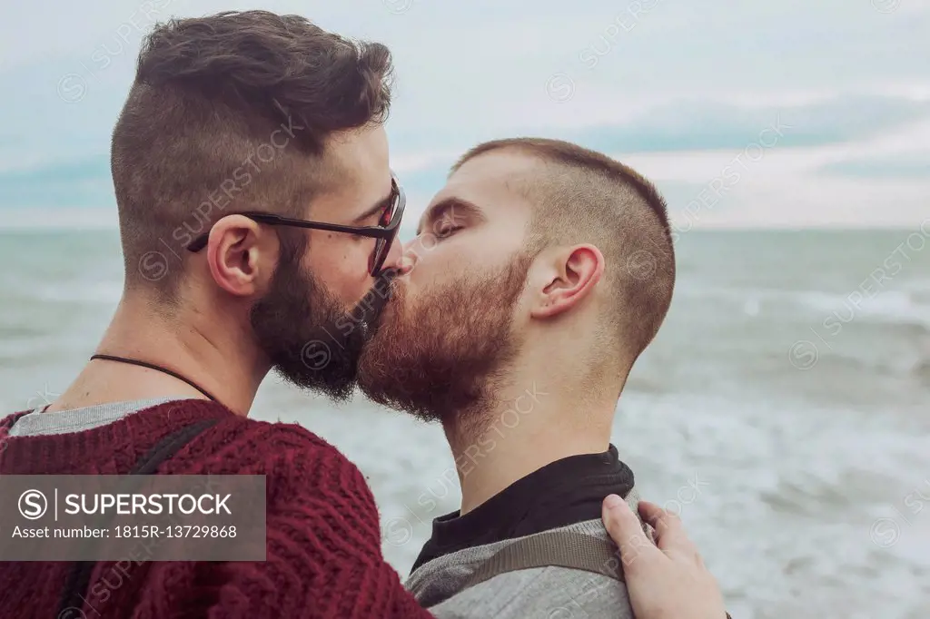 Gay couple kissing in front of the sea