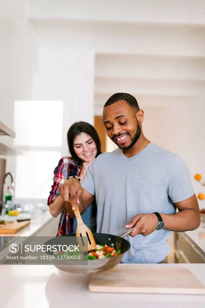 Young couple cooking together at home