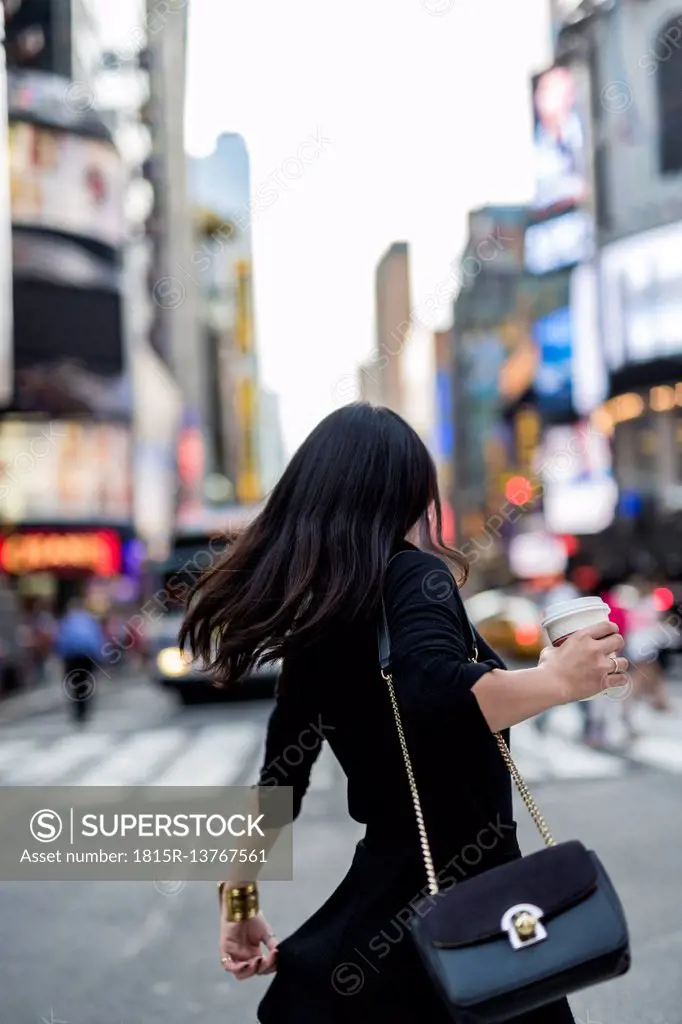 USA, New York City, Manhattan, back view of woman with coffee to go on the street