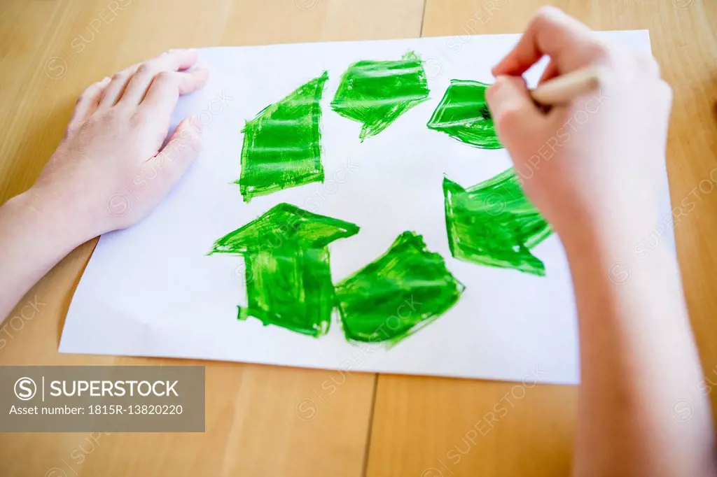 Close-up of girl painting recycling symbol