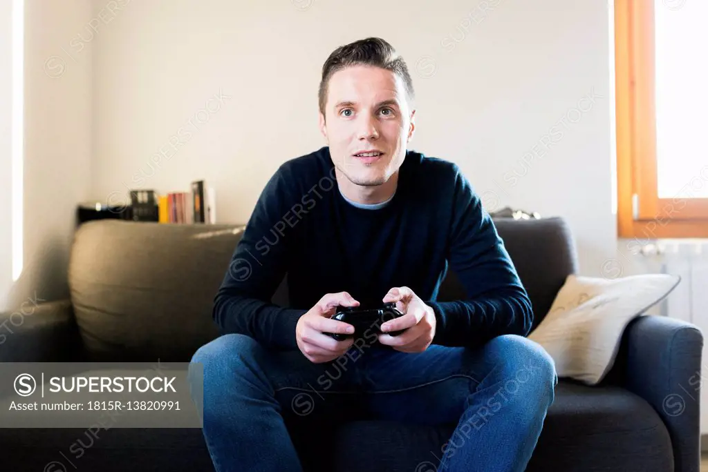 Man sitting on the couch playing with games console