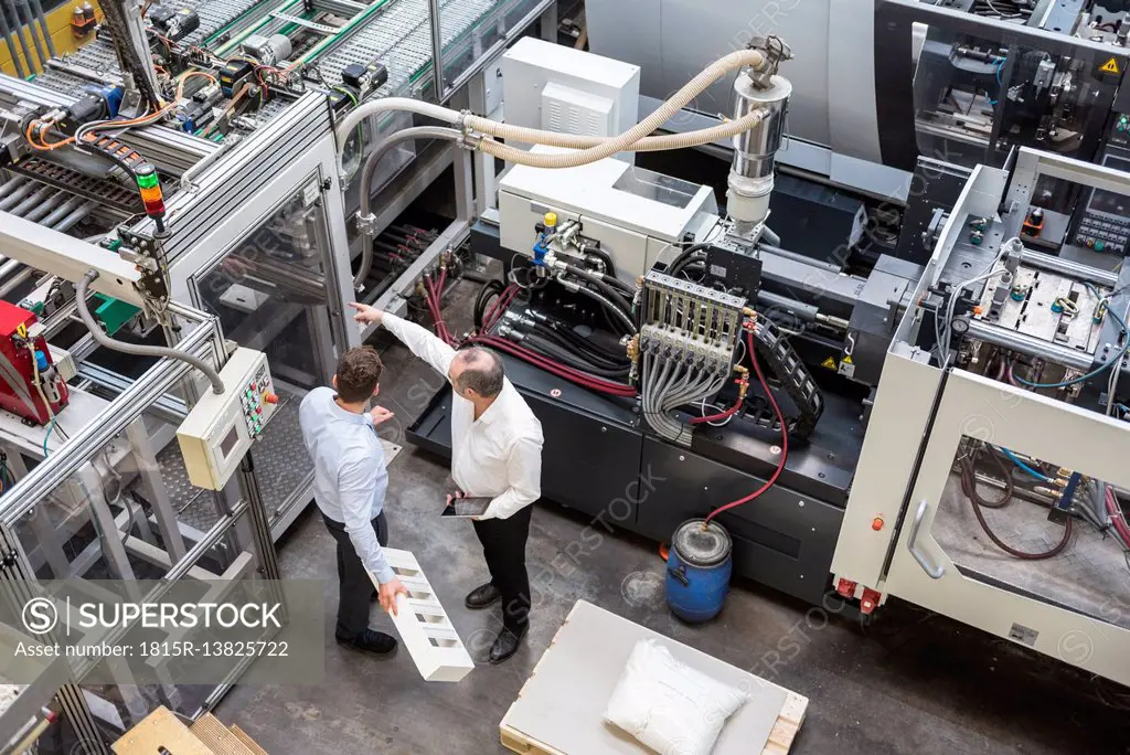 Top view of two men talking in factory shop floor