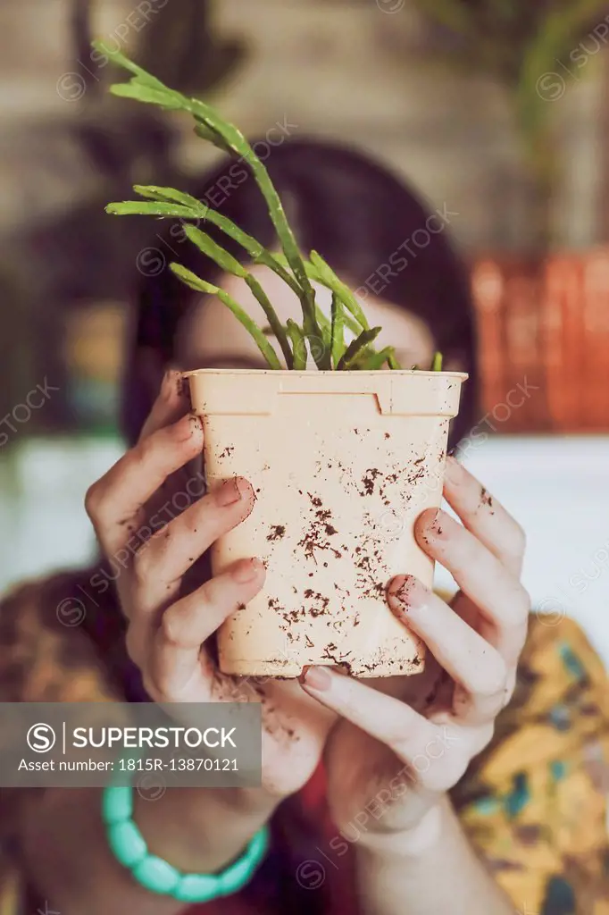 Young woman holding freshly potted cactus