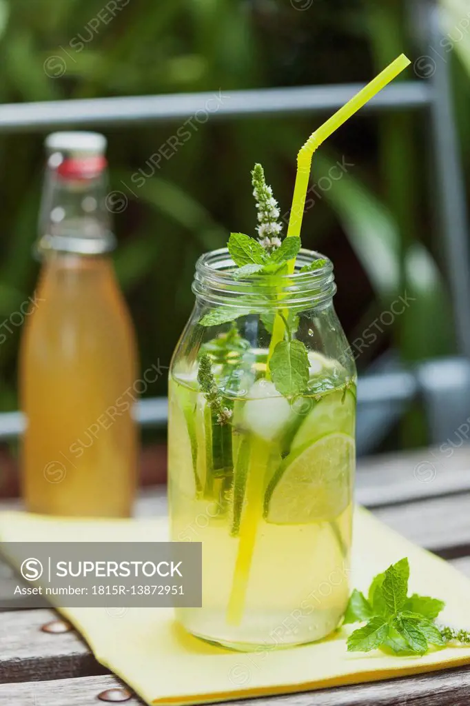 Glass of ice-cooled homemade cucumber lime lemonade with mint leaves