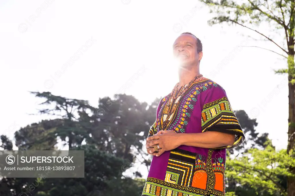 Portrait of smiling man standing at backlight wearing traditional Brazilian clothing