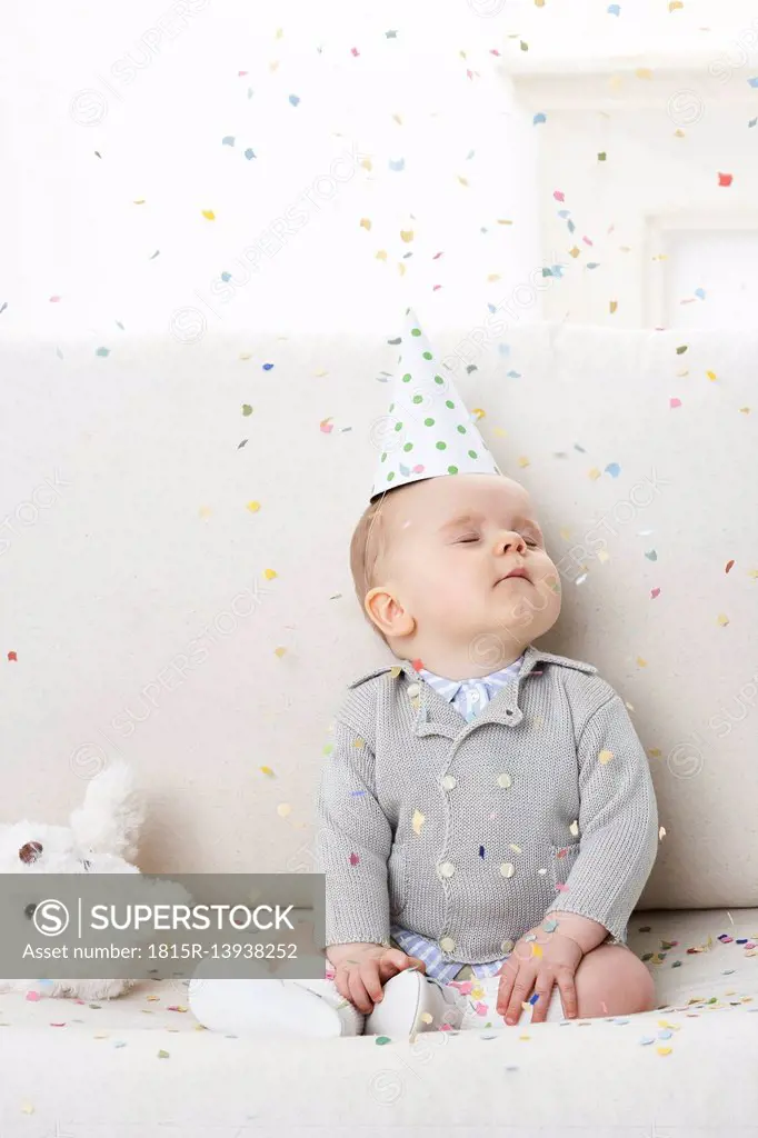 Portrait of baby boy with eyes closed wearing paper hat