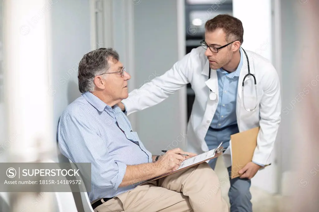 Doctor talking to patient with file in medical practice