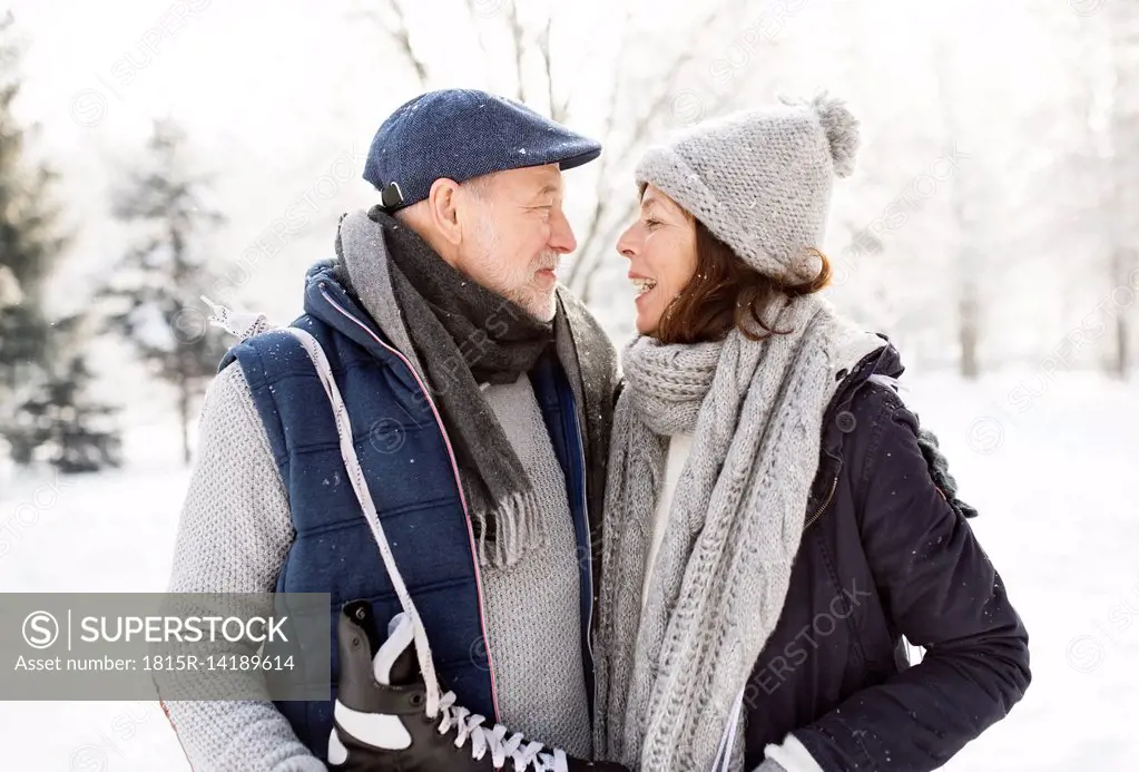 Senior couple with ice skates in winter landscape