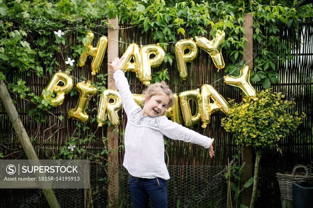 Portrait of girl in the garden with decoration for Birthday Party in the background