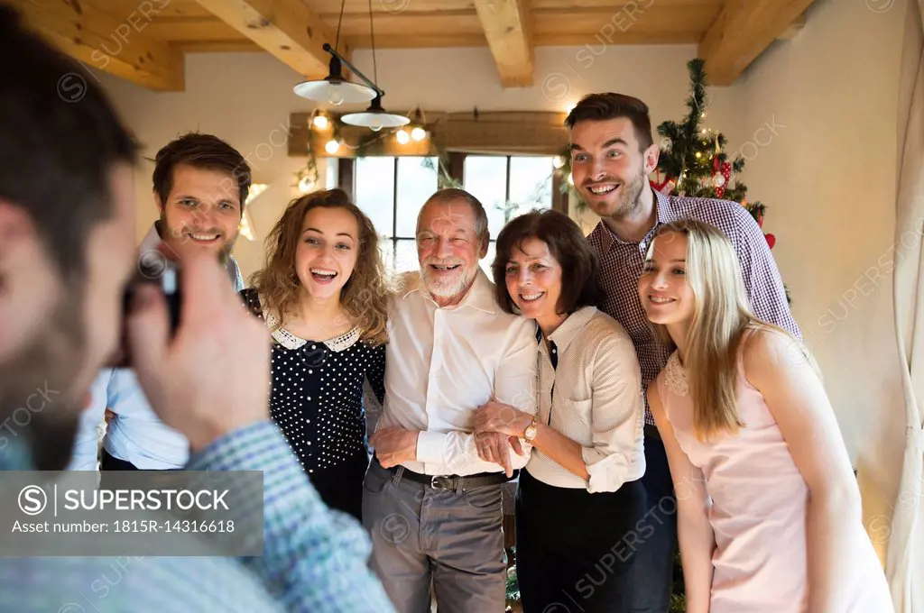 Family posing for a photo at Christmas tree