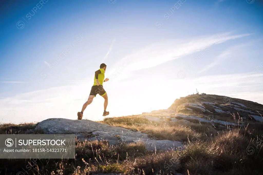 Italy, man running on mountain trail