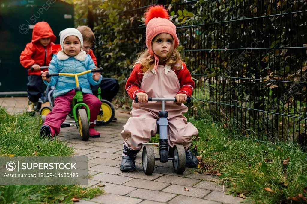 Children using scooters in garden of a kindergarten