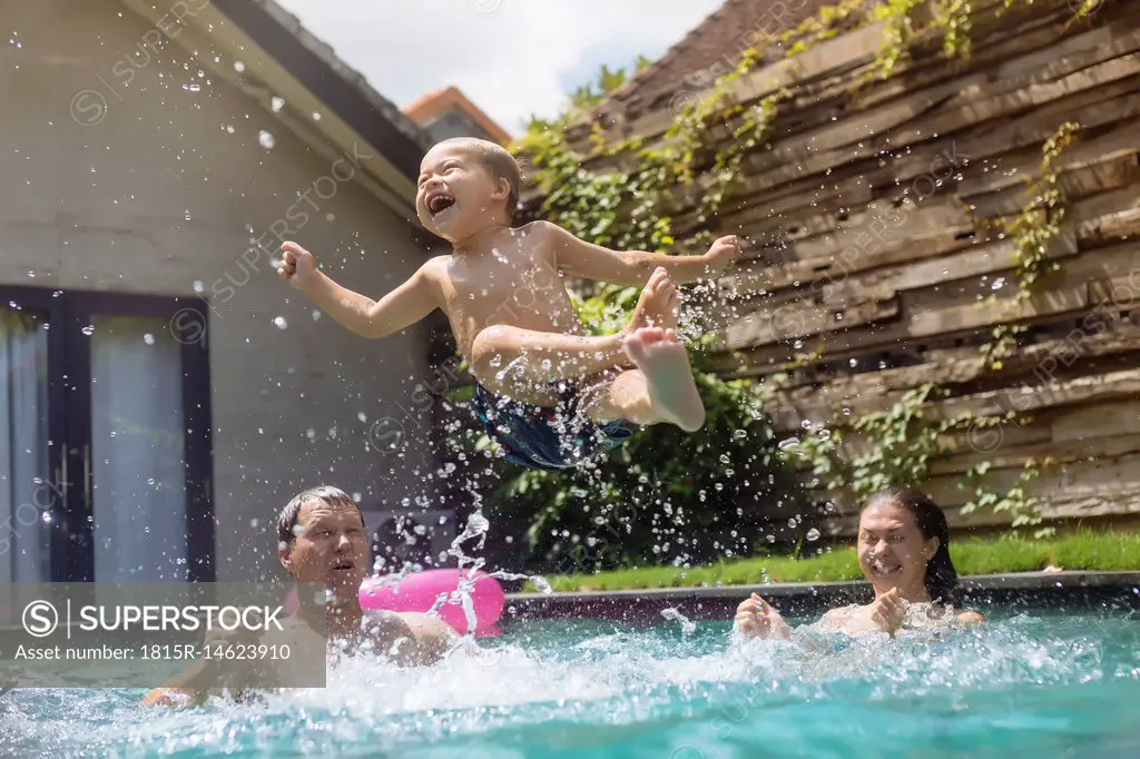 Happy family having fun in swimming pool