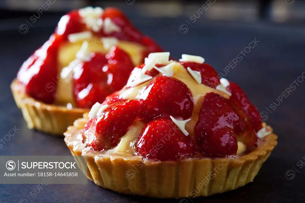 Strawberry tartlets with custard and white chocolate shaving