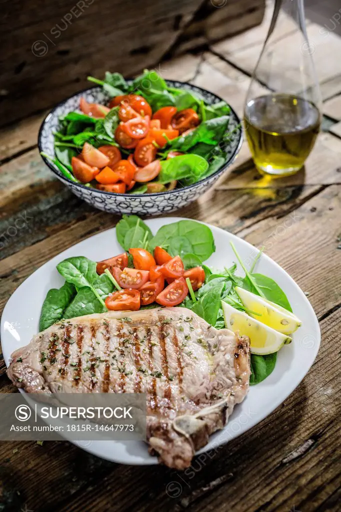 Roasted beefsteak with rosemary, spinach salad with tomato, lemon