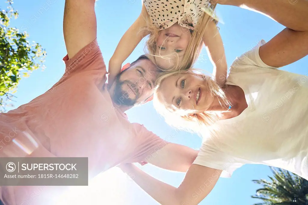 Portrait of happy family huddling under blue sky