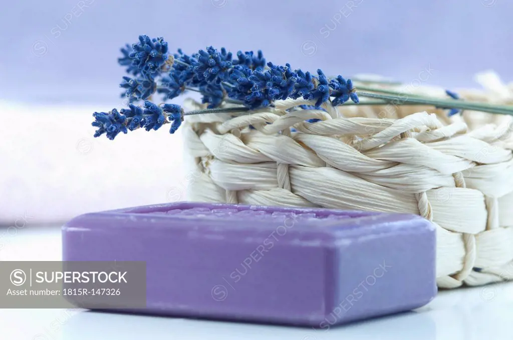 Twig of lavender on a basket and a piece of lavender soap