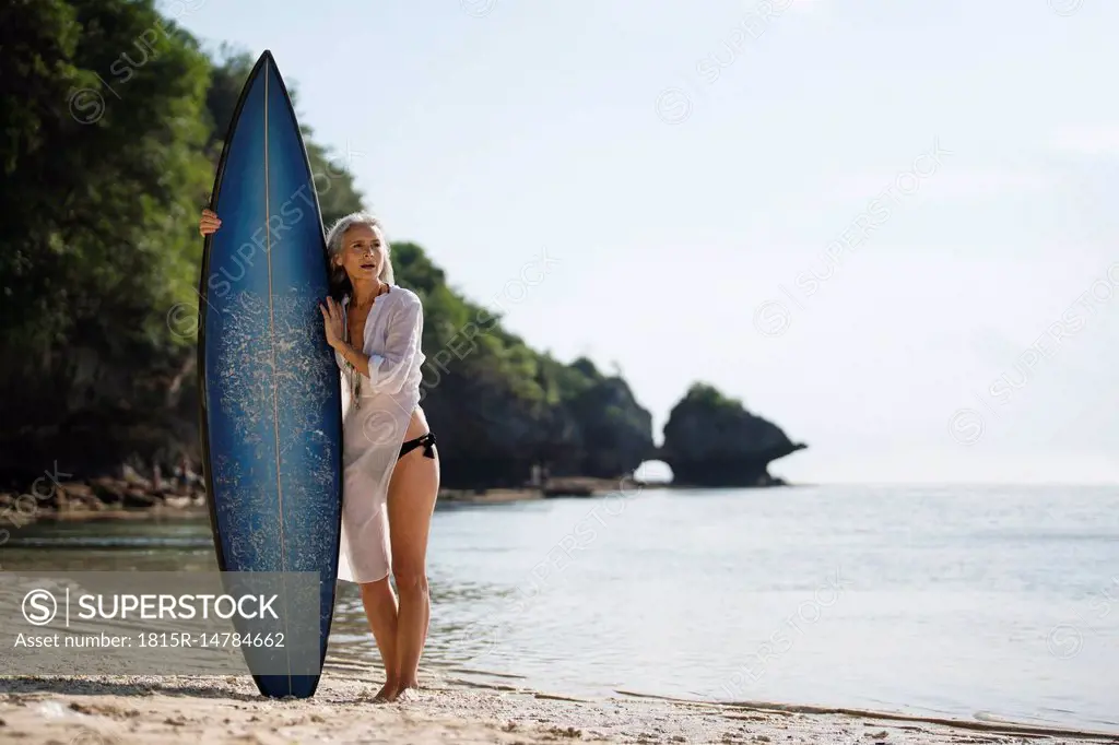 Affectionate senior couple with surfboards at beach