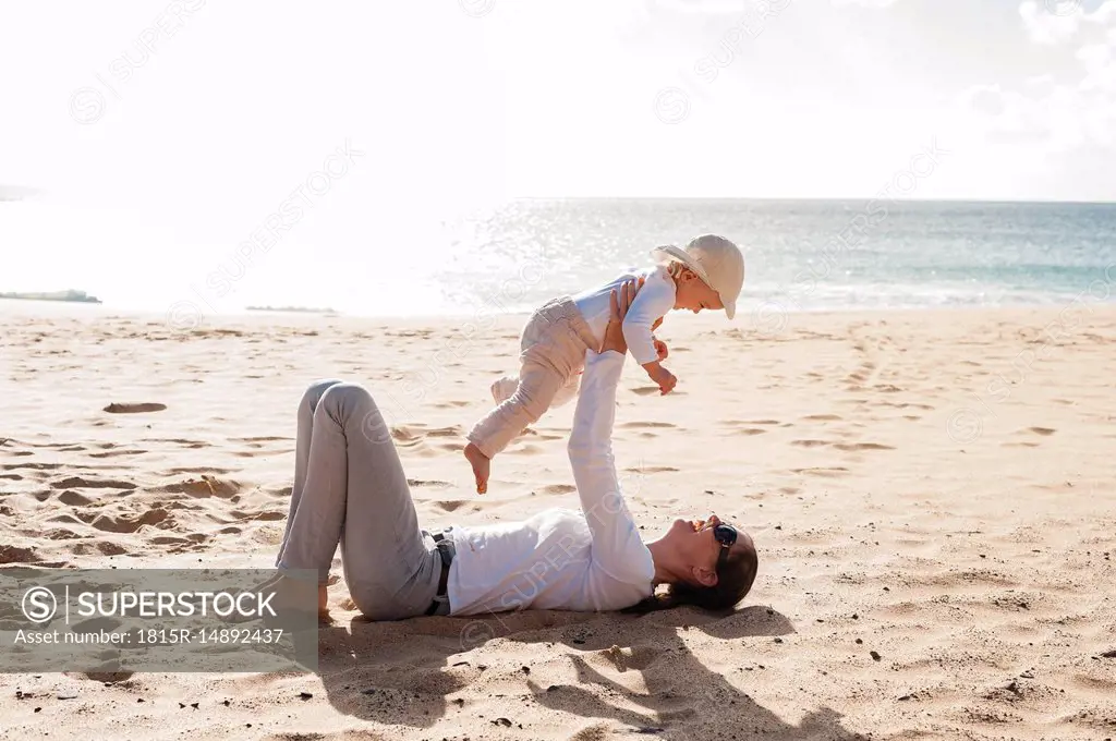 Happy mother with little daughter on the beach