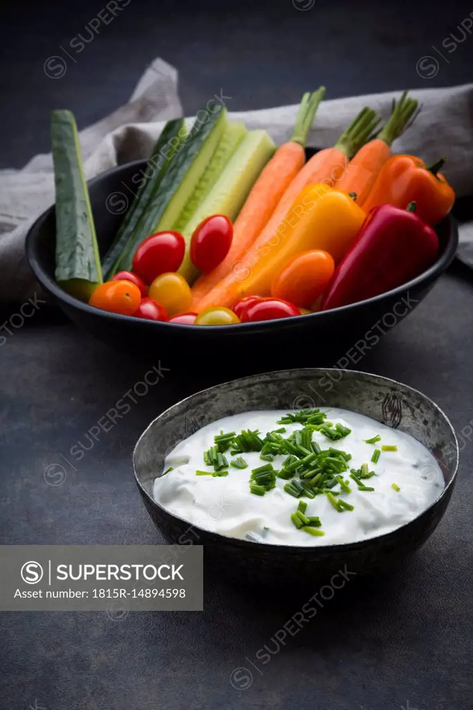 Bowl of chive dip, cherry tomatoes and various vegetable sticks