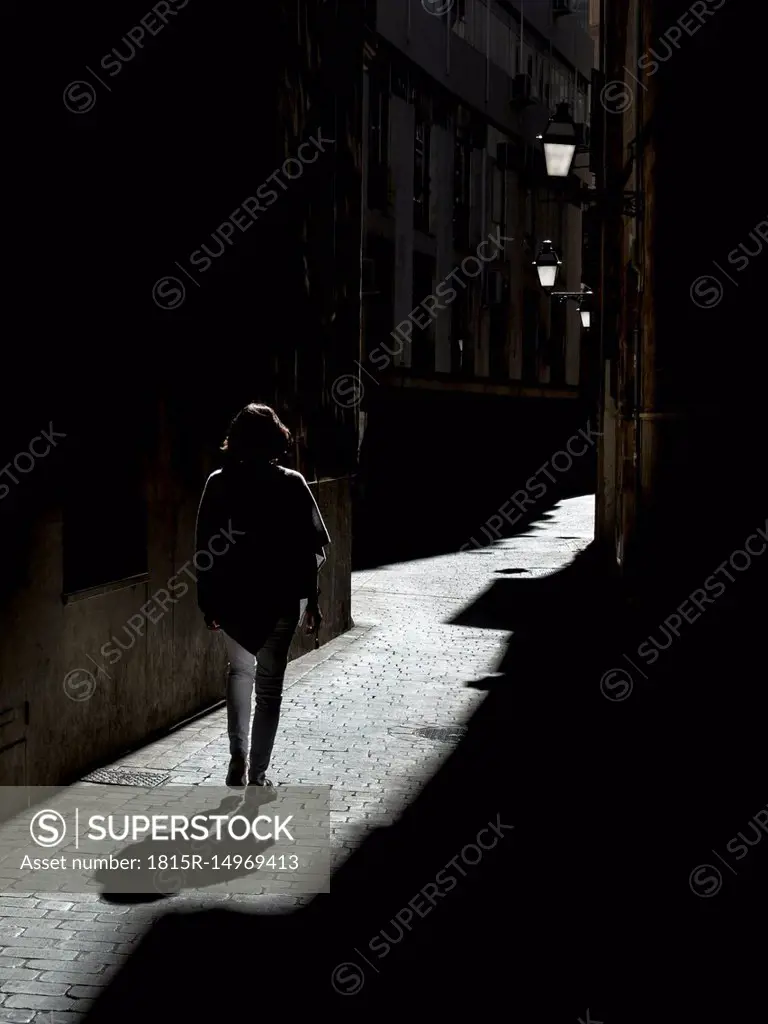 Spain, Palma de Mallorca, woman walking in alley