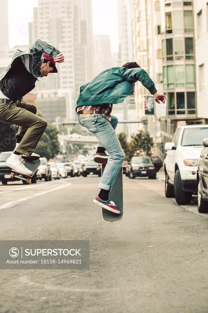 USA, California, San Francisco, two young men skating on the street