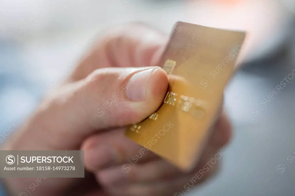 Man's hand holding credit card, close-up