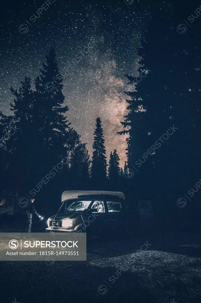 Canada, British Columbia, Chilliwack, man with torch at minivan at night