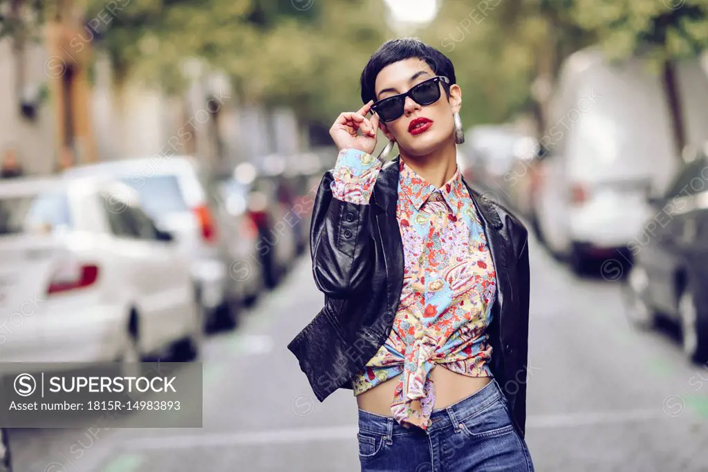 Portrait of fashionable young woman wearing sunglasses and leather jacket