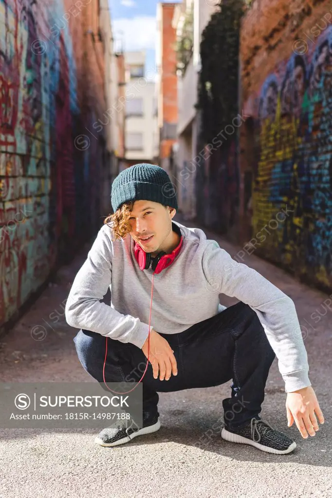 Portrait of young man with headphones wearing wool cap