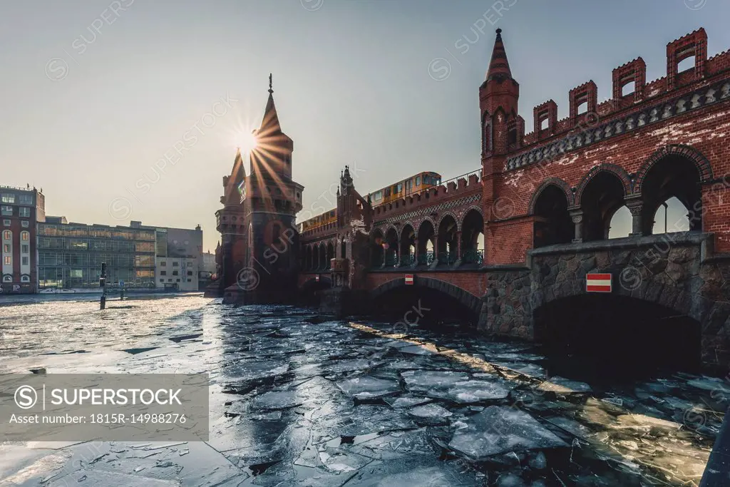 Germany, Berlin, view to Oberbaum Bridge with driving underground train in winter