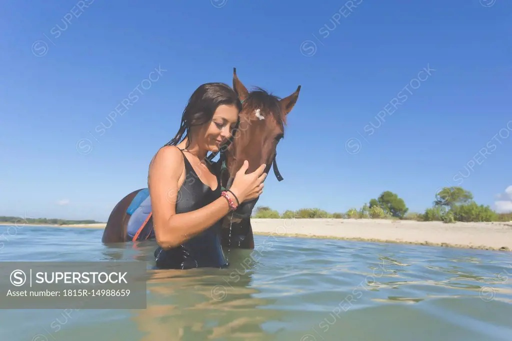 Indonesia, Bali, Woman with horse in the water