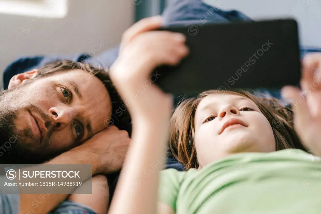 Father and son looking at smartphone together at home