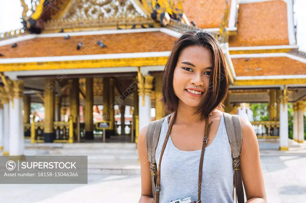 Thailand, Bangkok, portrait of smiling tourist with camera