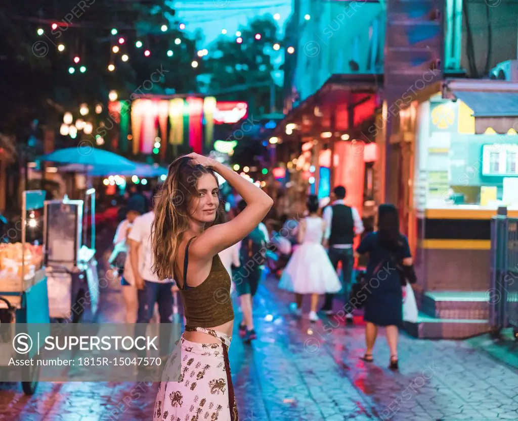 Thailand, Bangkok, young woman in the city on the street at night