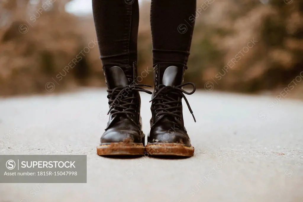 Woman wearing black boots, partial view