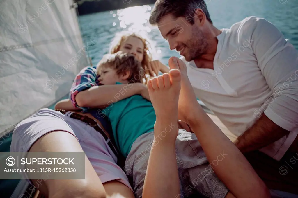 Happy family relaxing on a sailing boat