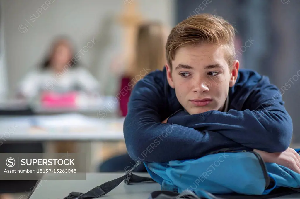 Serious teenage boy thinking in class