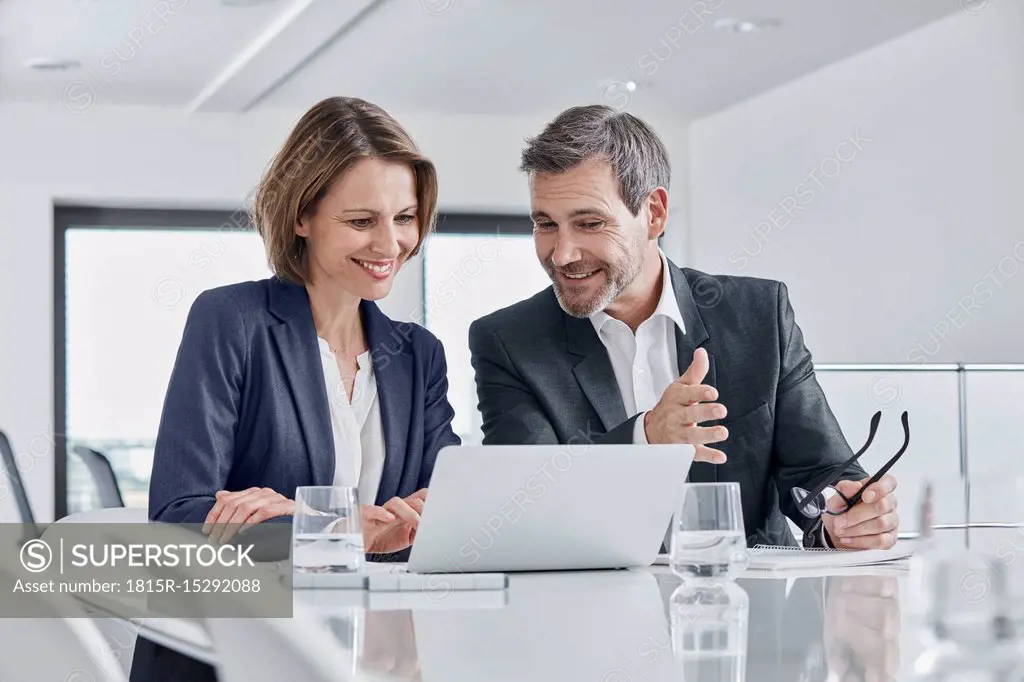 Businessman and businesswoman having a meeting in office with laptop