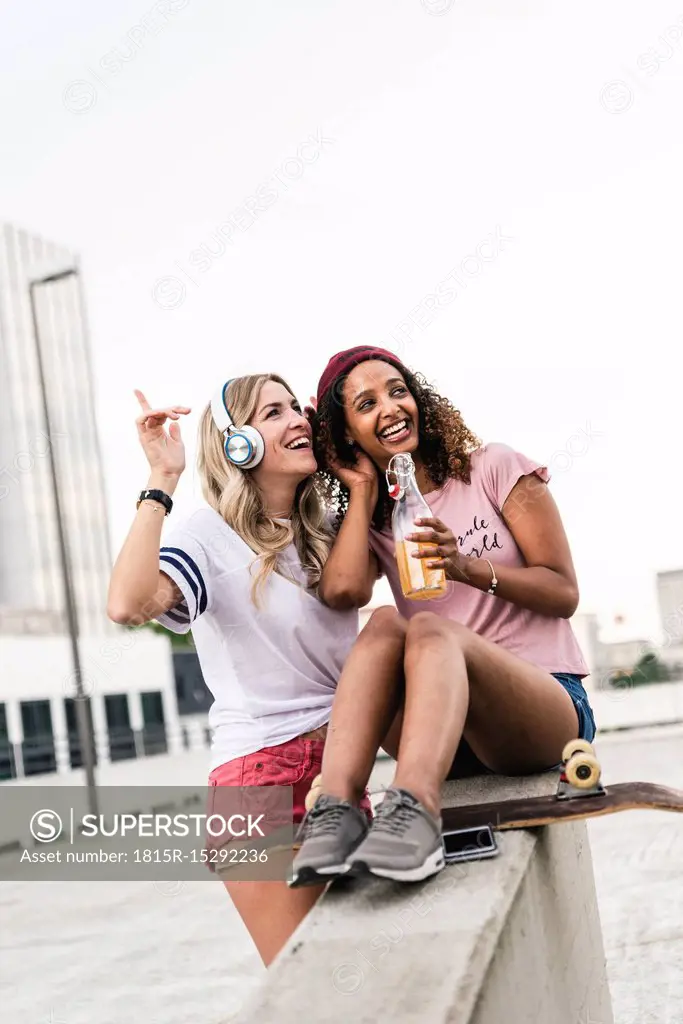 Best friends with skateboard, having fun together, listening music