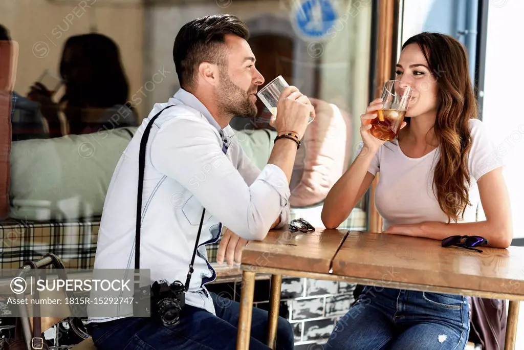 Couple having a drink at an outdoor bar in the city