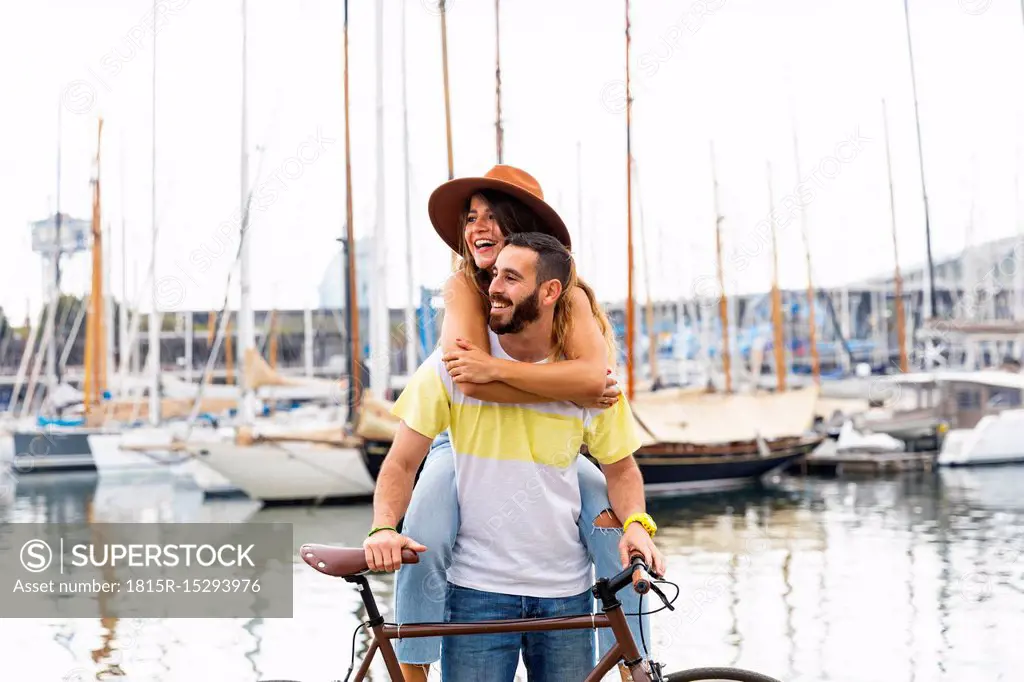 Spain, Barcelona, happy couple with bicycle at the seaside